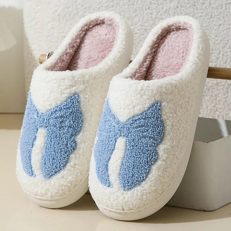 Cotton slippers with cartoon bow knot design on suede upper in pink or blue colours with TPR sole