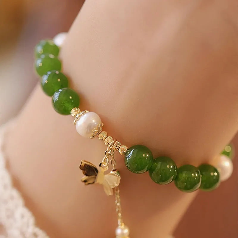 Close-up of a round natural green chalcedony bracelet on a woman's wrist.