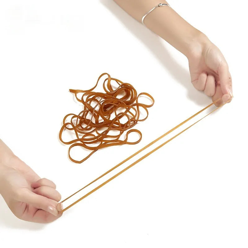 A bag containing many natural coloured, circular rubber bands with a label indicating 500g.