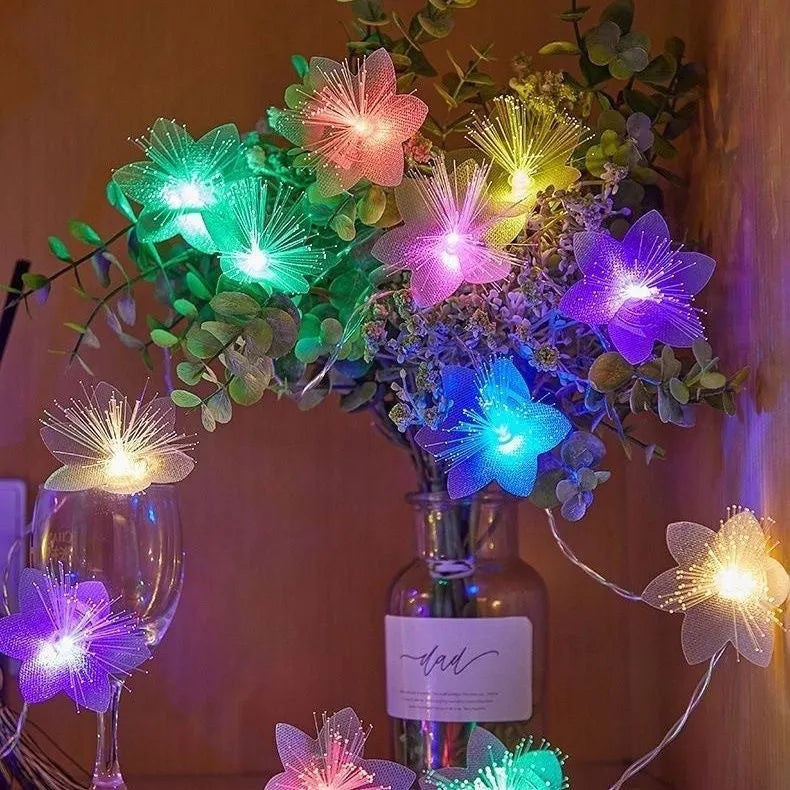 LED optical fibre flower light string with 20 warm white flower-shaped beads on a dark background