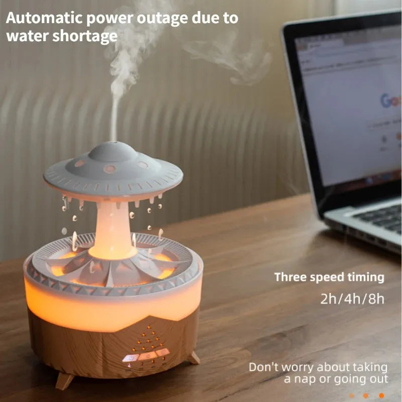 White cloud-shaped UFO raindrop humidifier diffuser with coloured night light on a wooden table.