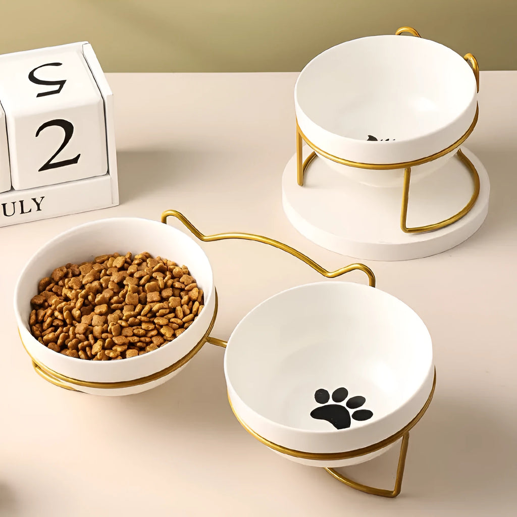 White ceramic cat bowl with cat paw design on a black iron stand