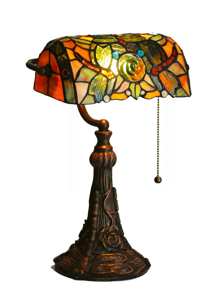 Tiffany stained glass table lamp with coloured lampshade and resin base on a desk