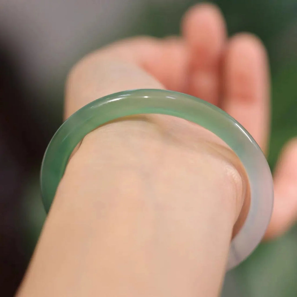 Chalcedony jade bead bracelet with semi-mountain, semi-water pattern on a model's wrist.