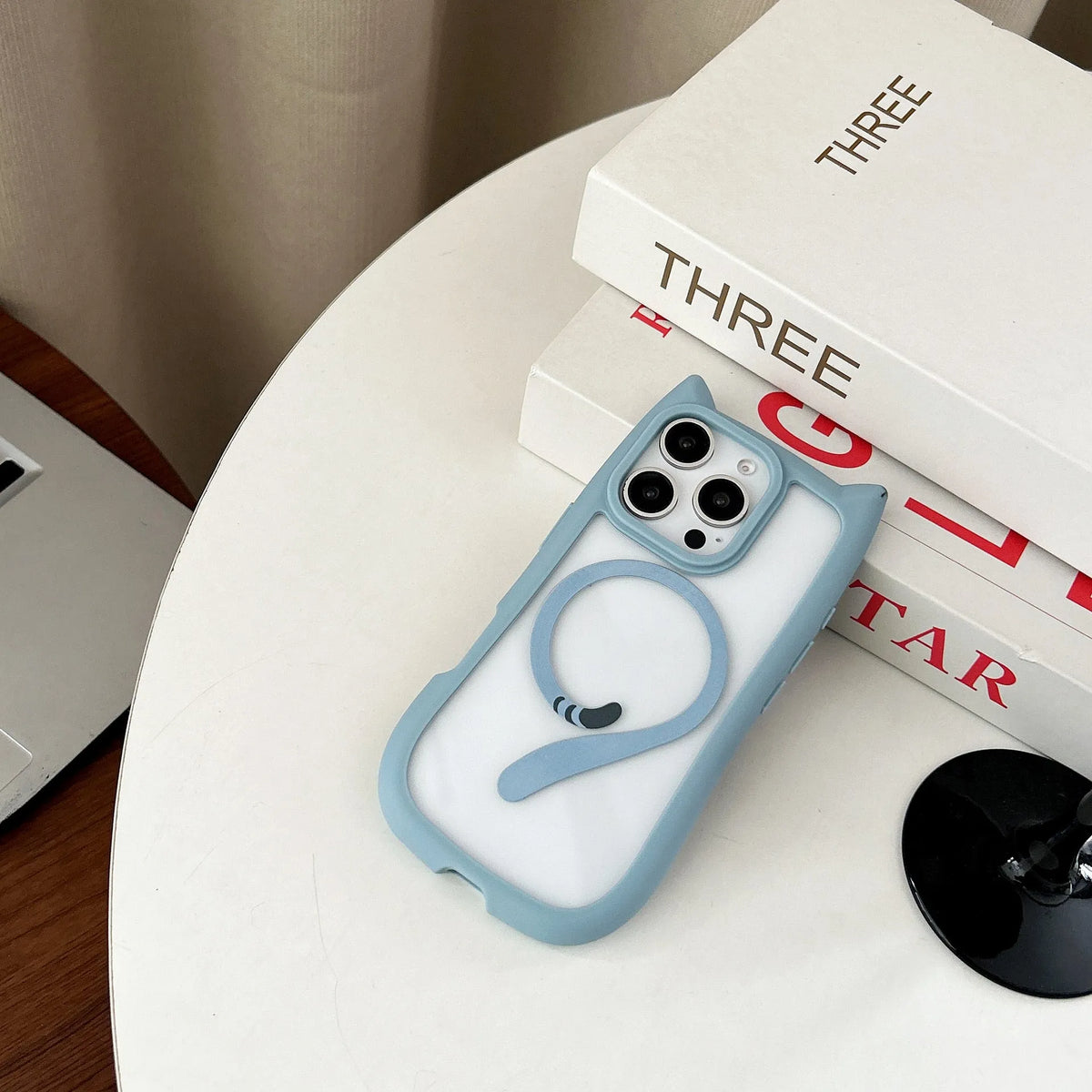 Transparent acrylic TPU phone case with magnetic ring for iPhone 17 models on a table.