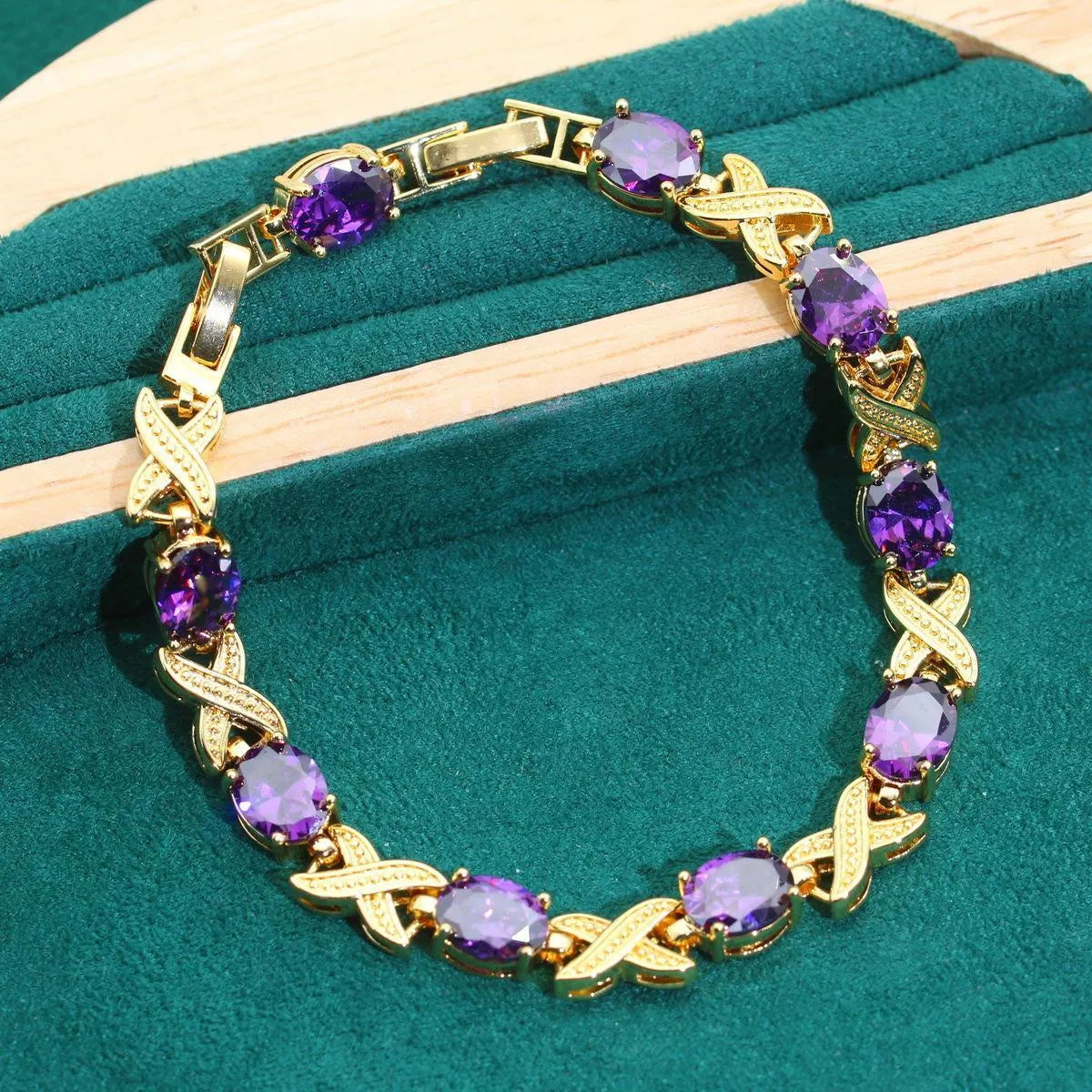 Gold-coloured jewellery set with sparkling blue cubic zirconia stones, showing necklace, earrings, ring, and bracelet.
