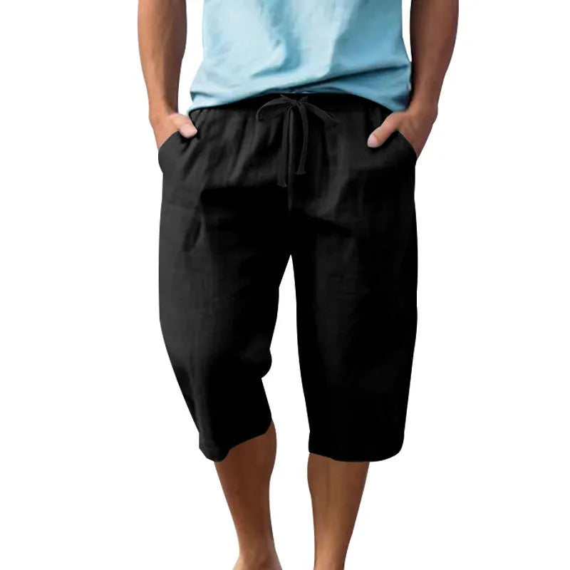 Men's loose linen shorts in light blue with drawstring waist and cropped length on white background