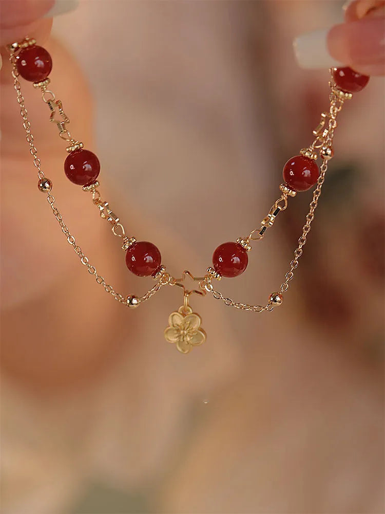 Red agate double layer bracelet with peach blossom floral details on woman's wrist