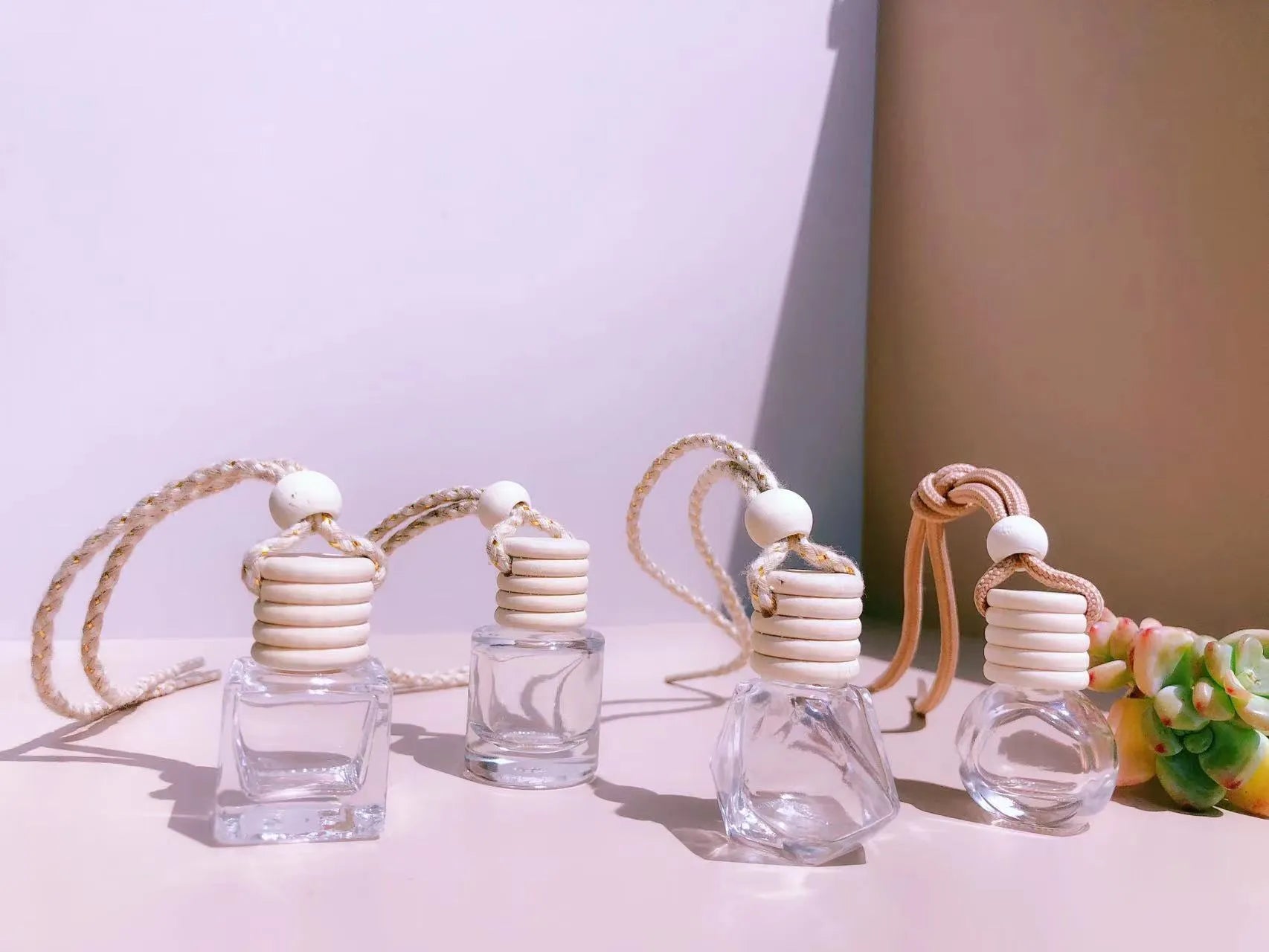 Car perfume pendant in glass bottle showing cylinder, diamond, flat drum and square style options