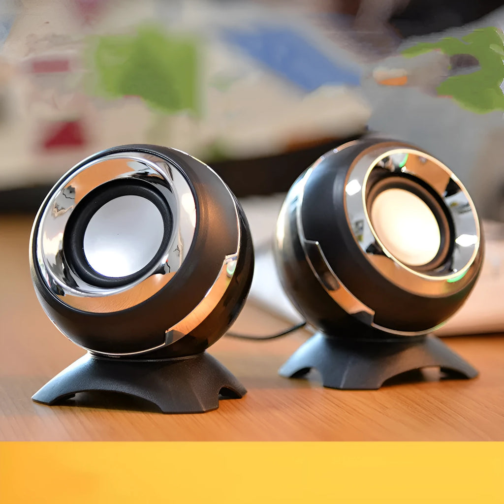 Compact black and gold USB-powered desktop stereo speakers next to a laptop.