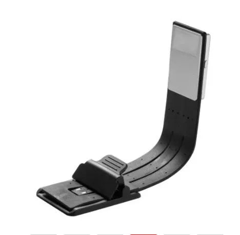 Black folding LED reading lamp clipped to a Kindle e-reader showing adjustable brightness settings