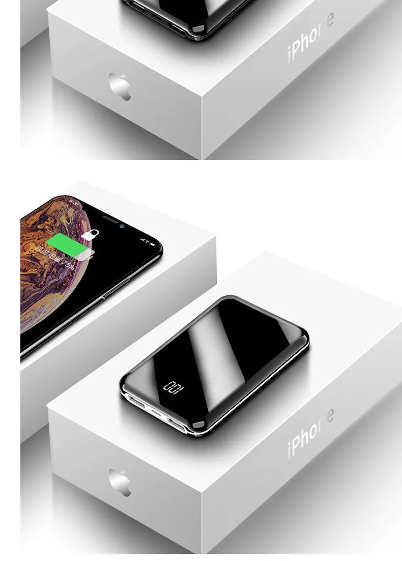 Black mini power bank with digital LCD screen showing battery percentage, next to a smartphone.