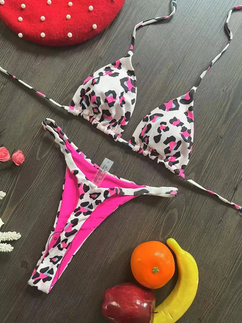 Women's printed bikini swimsuit on a hanger, showing briefs style with quick-drying fabric and cotton lining.