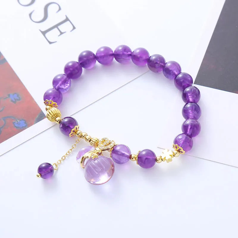 Purple crystal bracelet with geometric shapes, money bag pendant and peace buckle on wrist