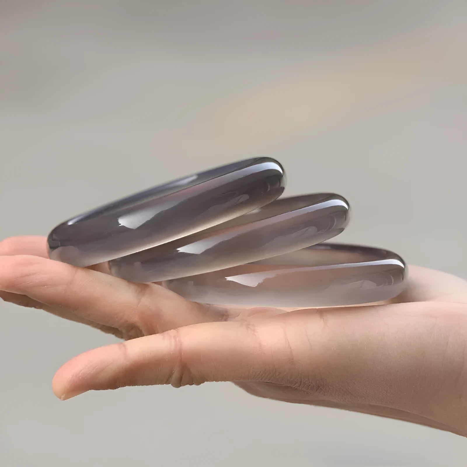 Dark grey iced chalcedony agate bracelet with a continuous circle design on a wrist.