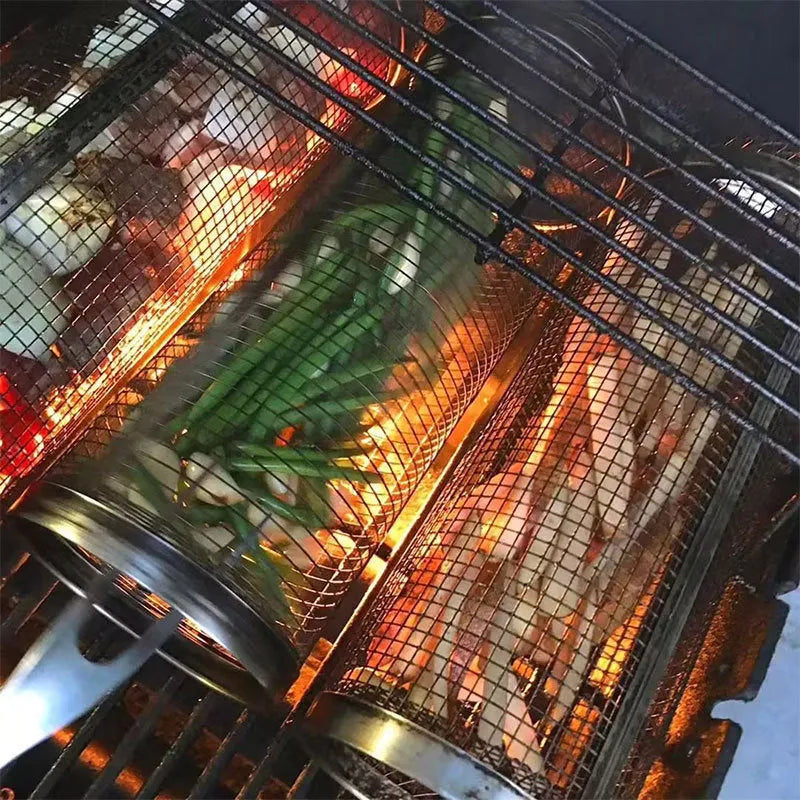 Round rolling metal barbecue grill basket with mesh sides and a handling hook, shown with BBQ gloves.