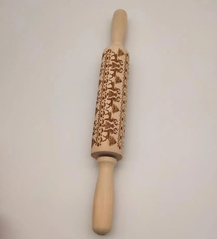 Wooden rolling pin with embossed Christmas patterns, 45cm long, on a kitchen worktop.