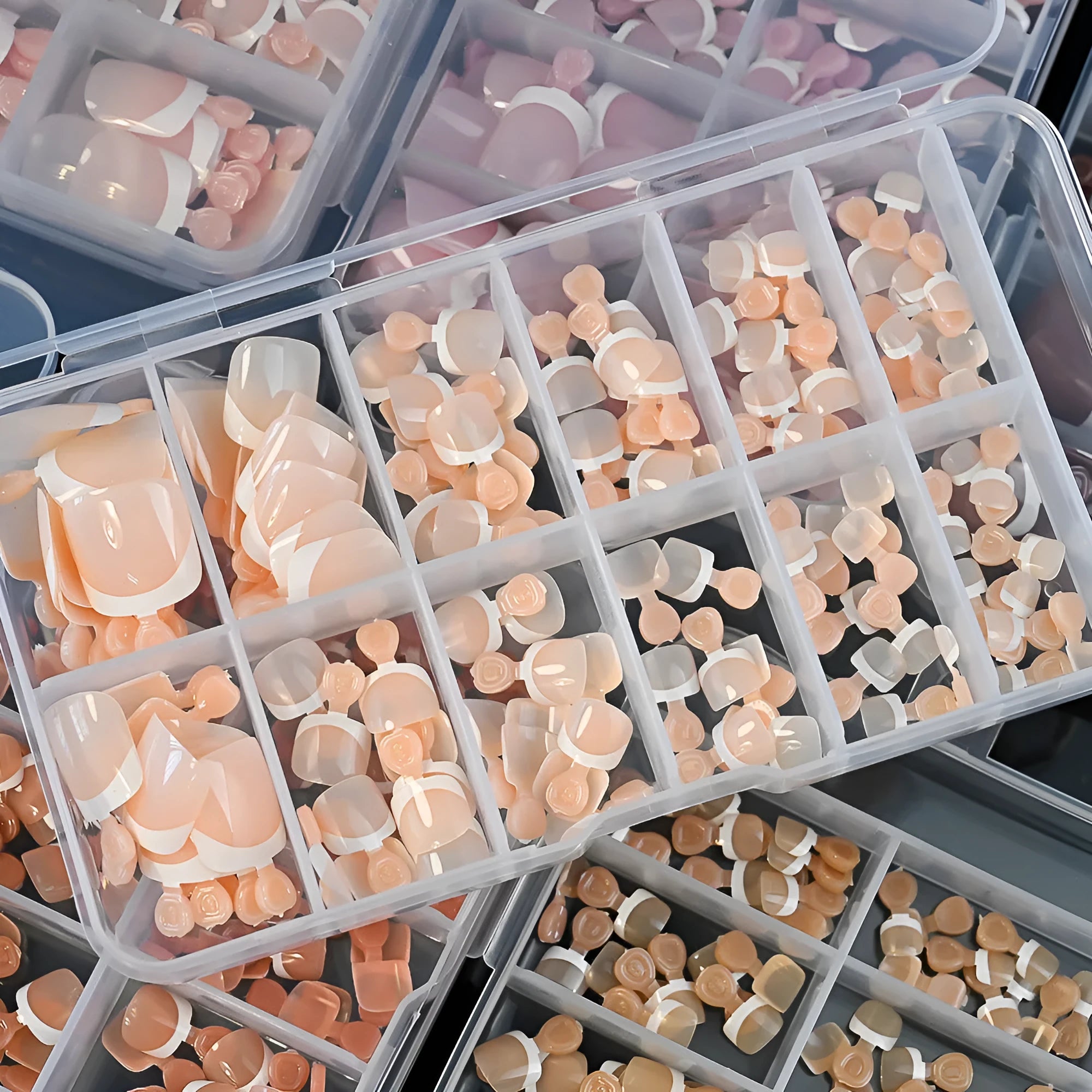 120 piece box of French white edge full square short nude artificial nail tips in nine shades.