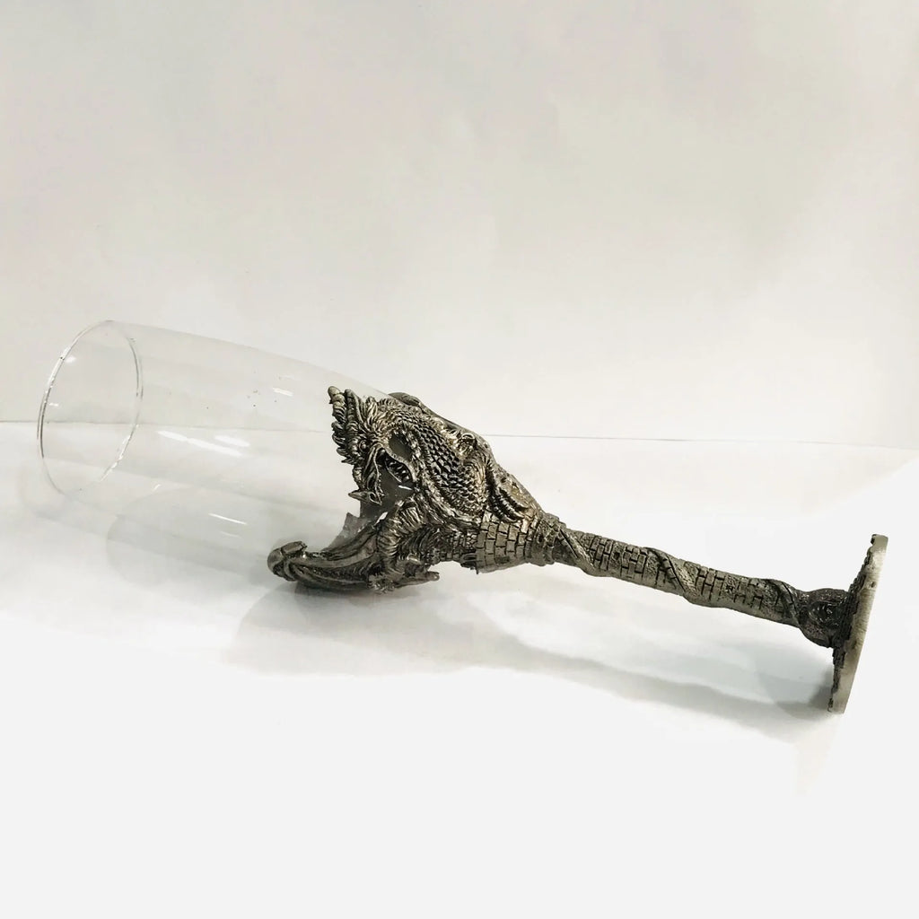 Alloy dinosaur champagne glass goblet in ancient tin colour on a surface, 21cm tall, retro style