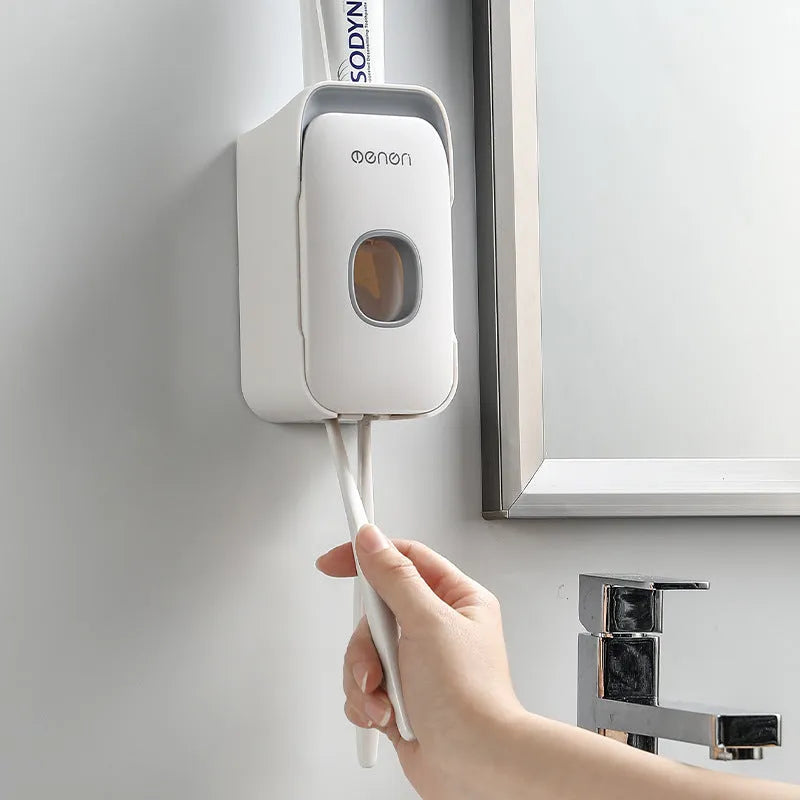 Automatic wall-mounted toothpaste dispenser in blue, grey, or pink ABS plastic with electric pump