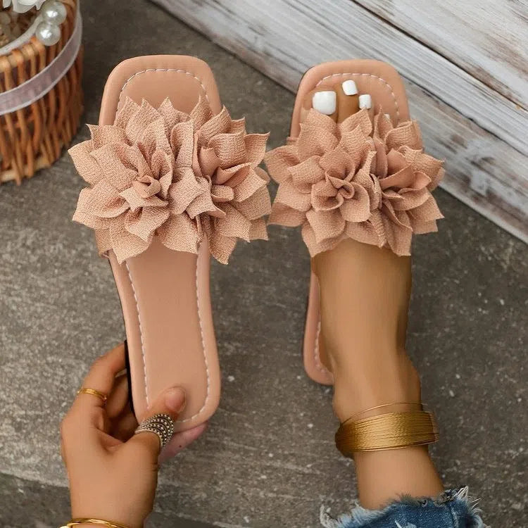Women's flat flip-flops with flower detail on PU upper, available in apricot, black, white, red, and green