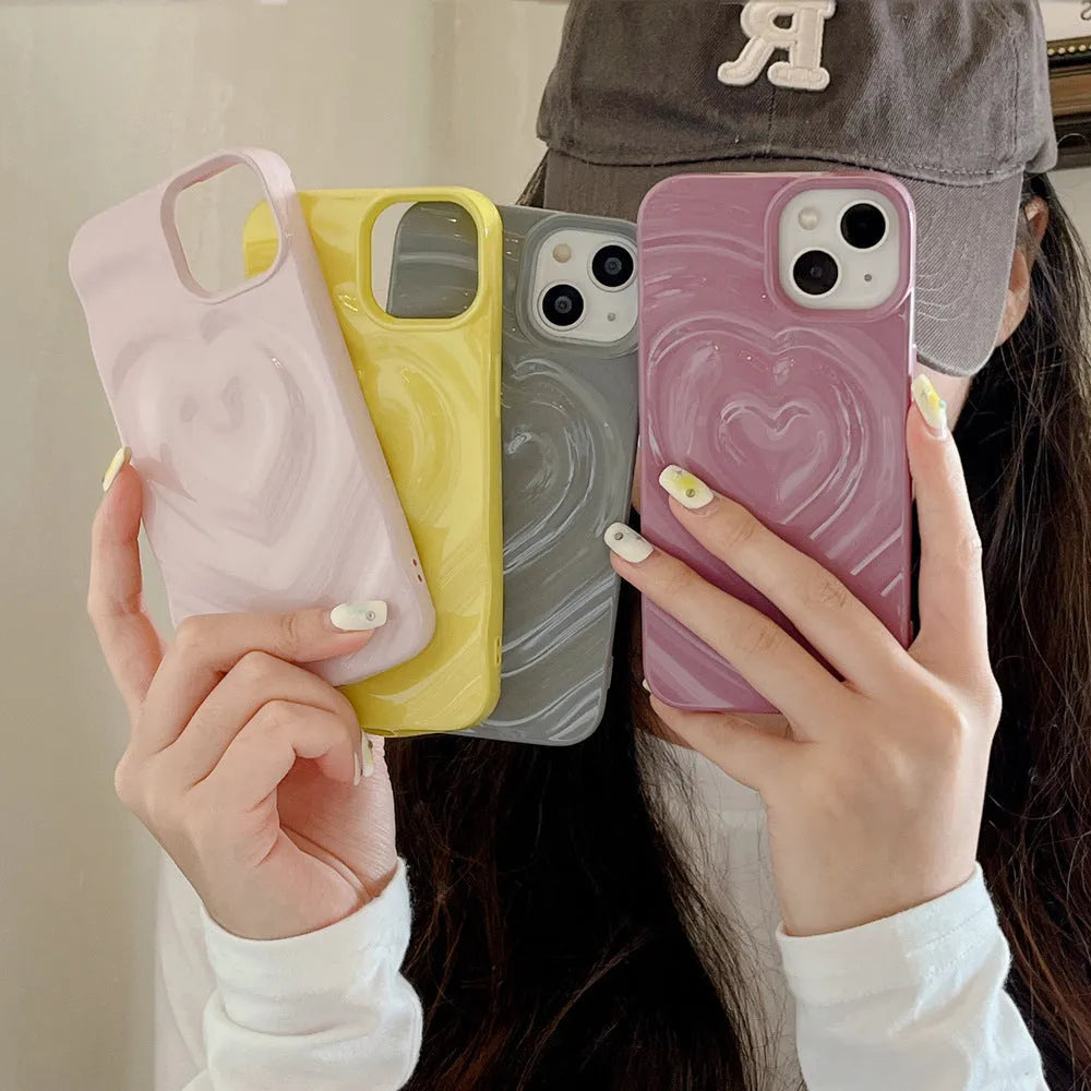 Solid colour iPhone case with a raised 3D love design on the back, shown in bright purple.