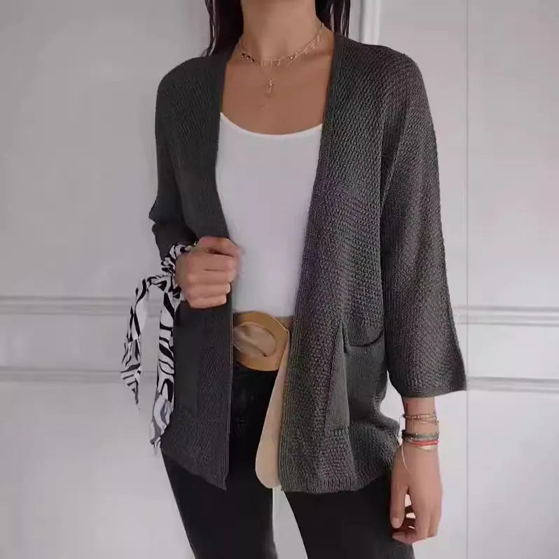Women's waffle-knit cardigan coat in army green, showing texture and pocket detail.
