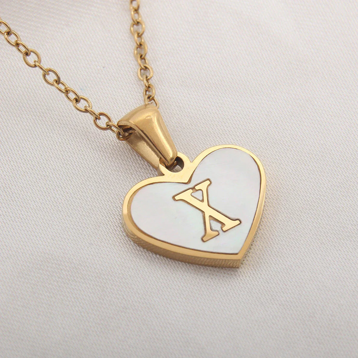 A personalized heart-shaped necklace with a 26-letter charm, crafted from high-quality stainless steel and gold plating.