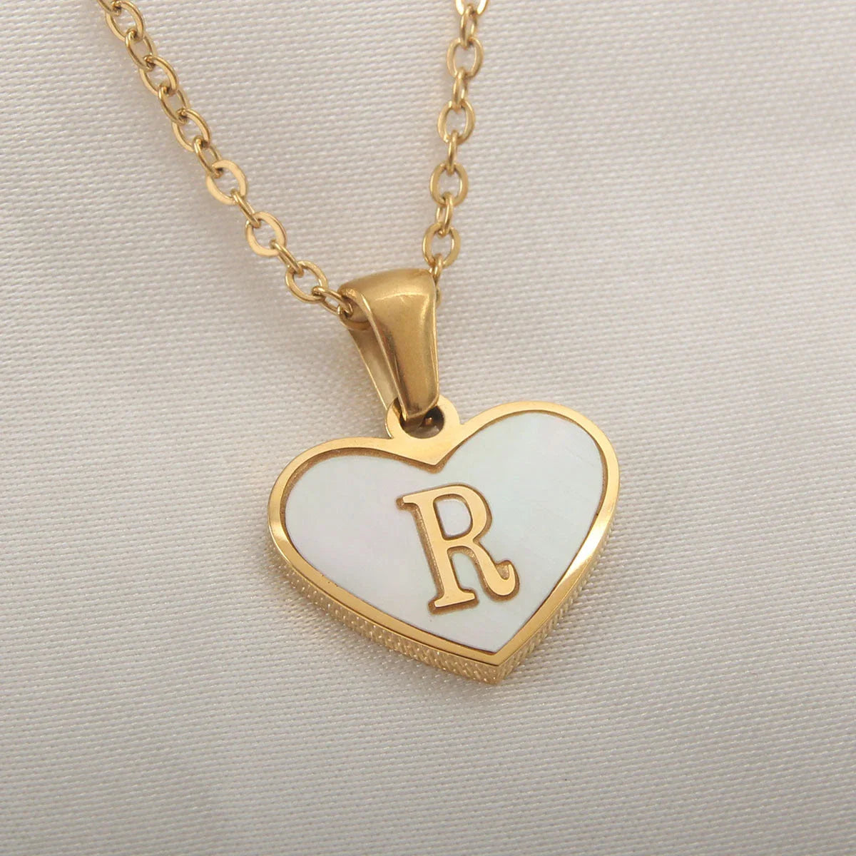 A personalized heart-shaped necklace with a 26-letter charm, crafted from high-quality stainless steel and gold plating.