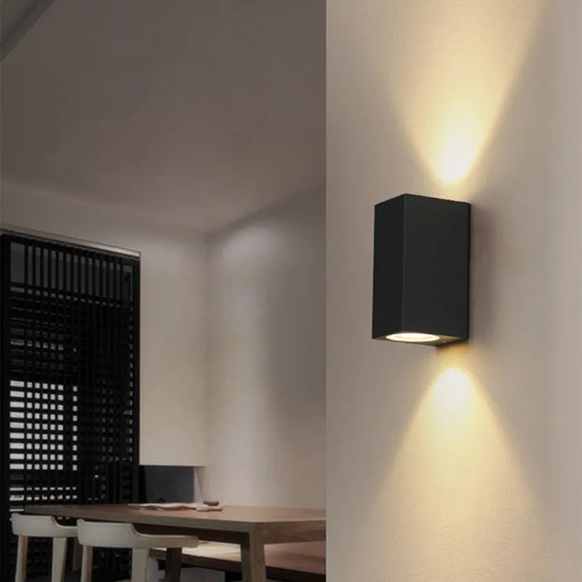 Modern black wall lamp with aluminium body, glass shade, and integrated LED light source.