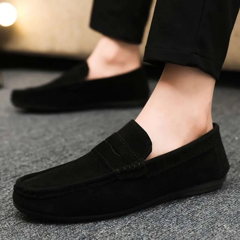 Men's black Gommino style slip-on loafers with round toe and textured rubber sole.