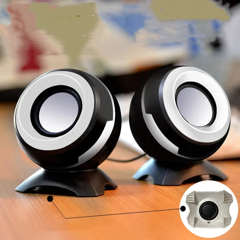 Compact black and gold USB-powered desktop stereo speakers next to a laptop.