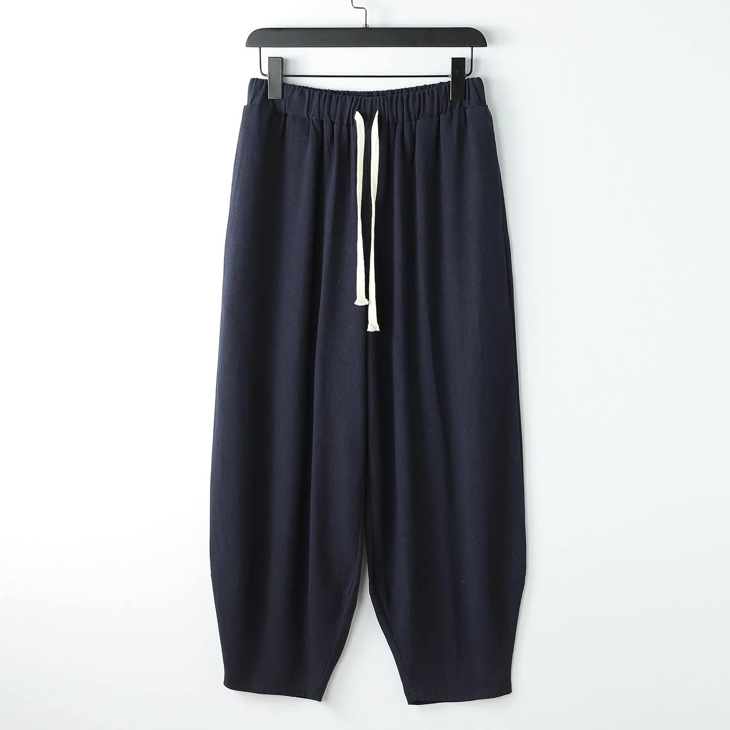 Loose fit linen harem pants with tapered legs and ankle ties on a mannequin, showing elasticated waist.