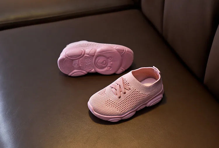 Children's white fabric lazy shoe with a non-slip rubber sole, shown on a foot.