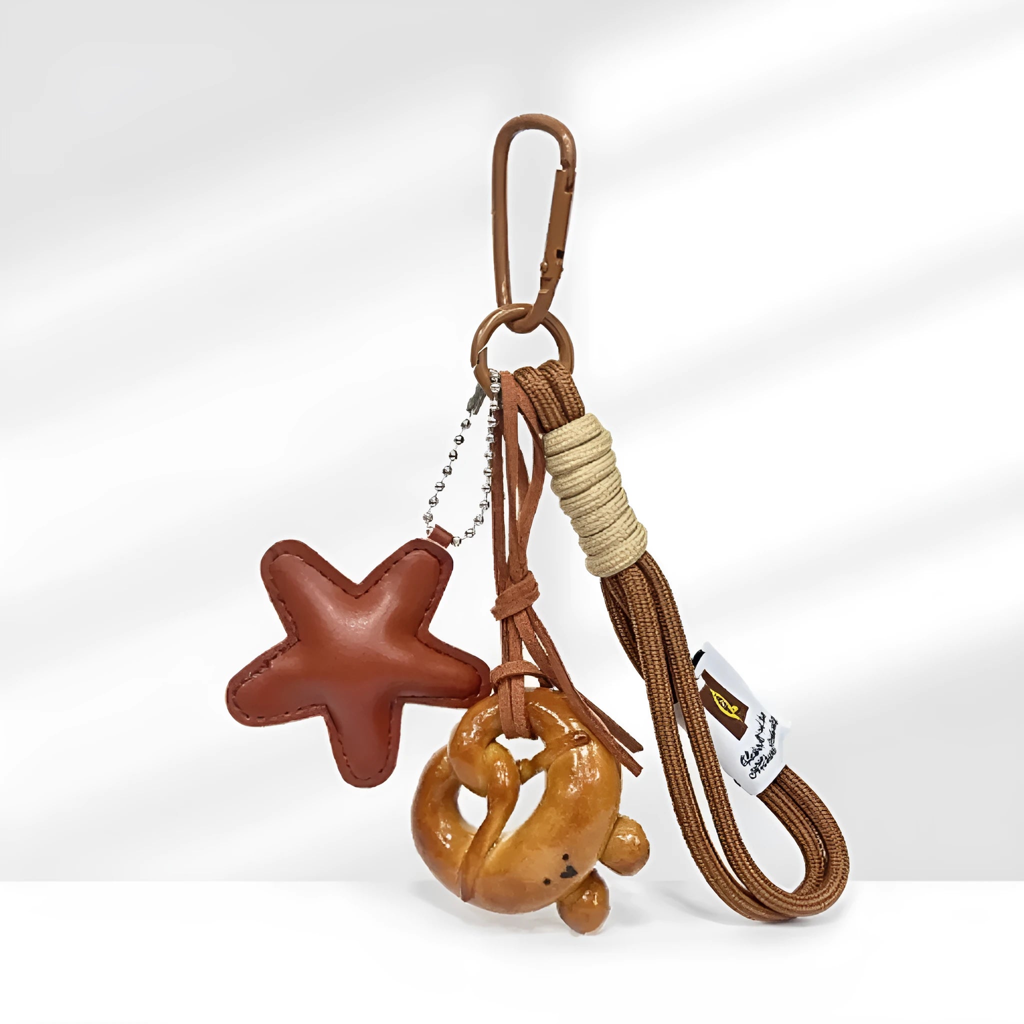 Handmade soda bread handbag pendant with baking varnish finish and brown star on brown strap.