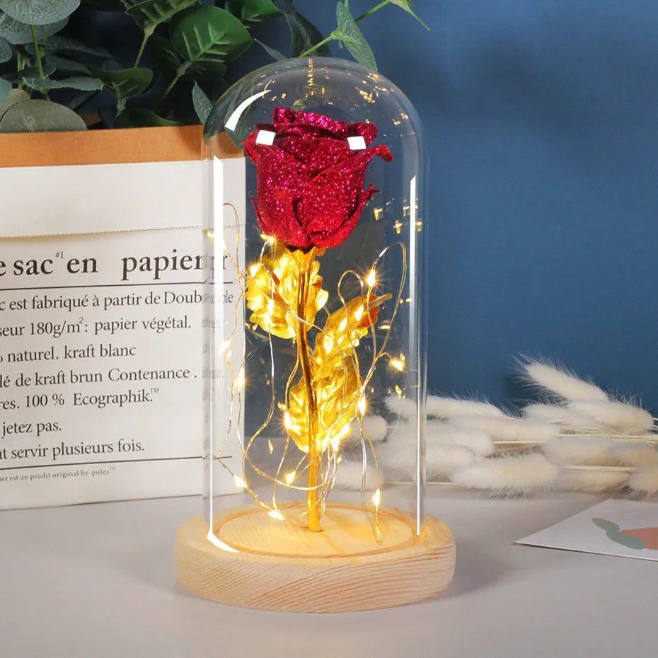 Glass dome covering a red eternal rose with coiled battery-powered LED lights on bendable copper wire.