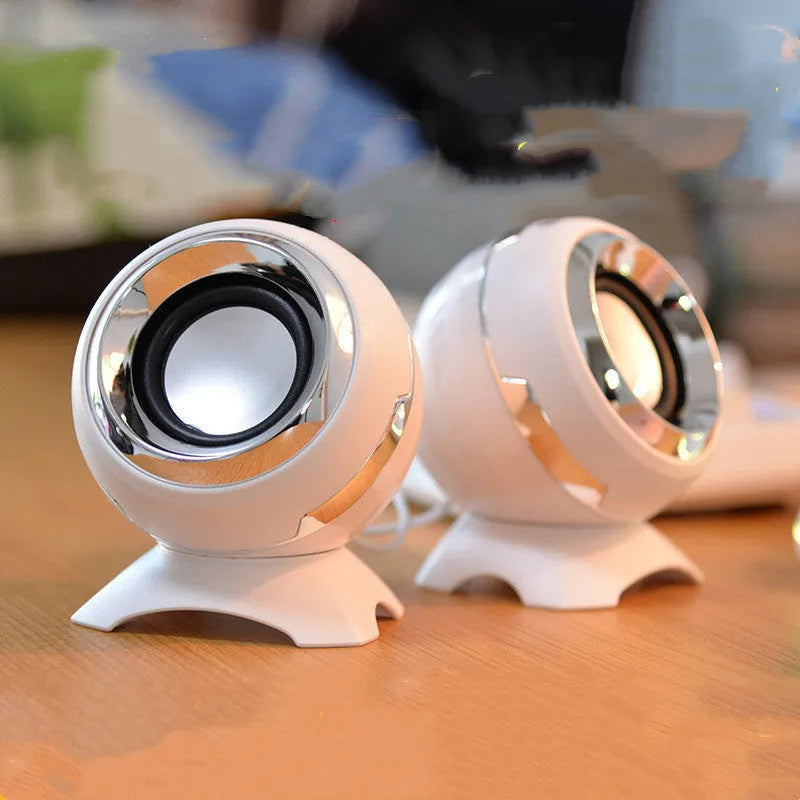 Compact black and gold USB-powered desktop stereo speakers next to a laptop.
