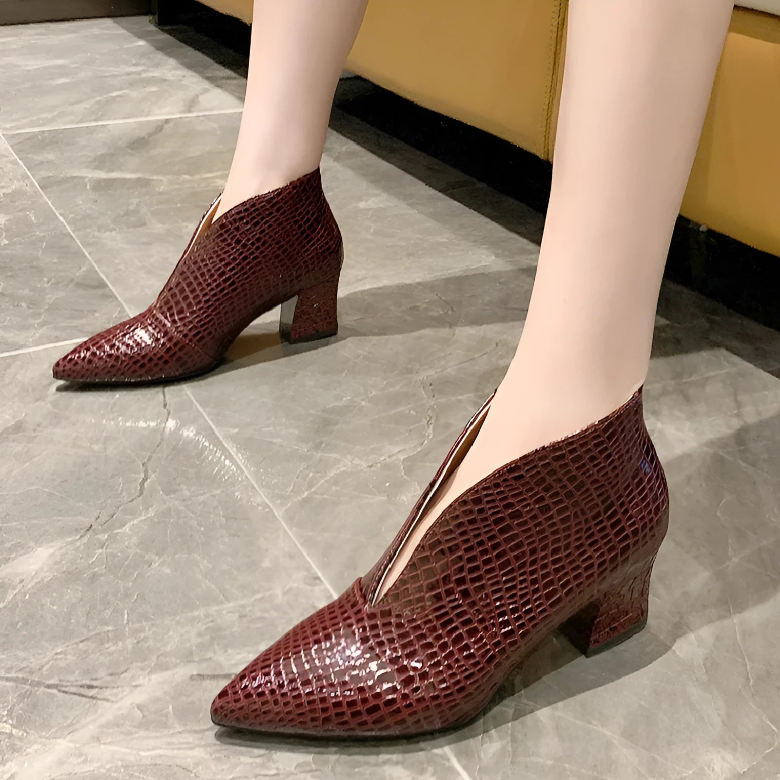 Women's black ankle boots with V-cut design, embossed texture, and chunky heel