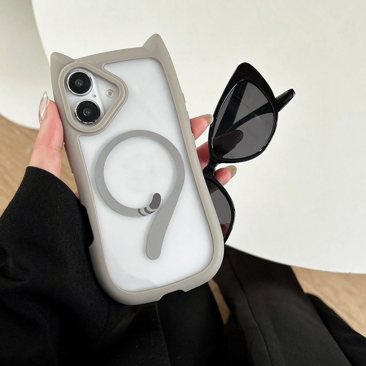 Transparent acrylic TPU phone case with magnetic ring for iPhone 17 models on a table.