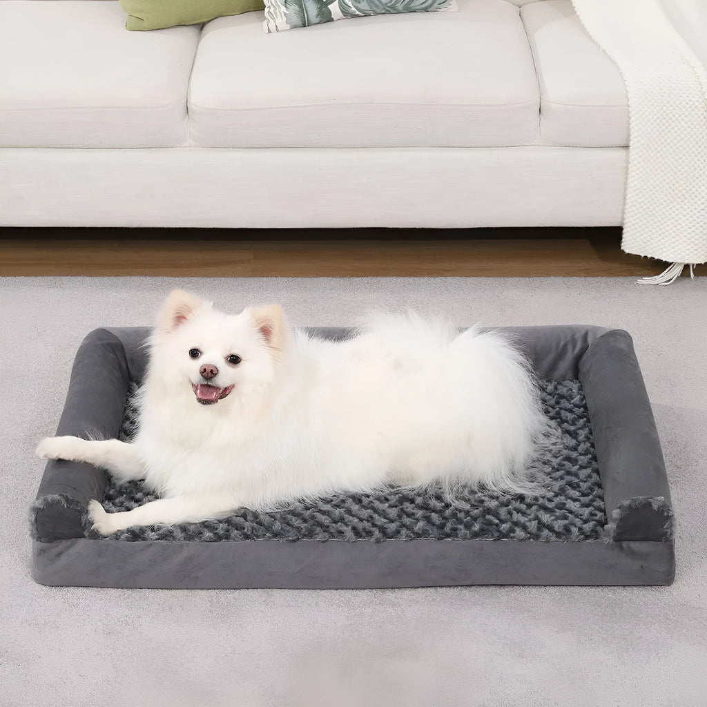 Grey U-shaped velvet dog sofa bed with removable cover, shown in a home setting.