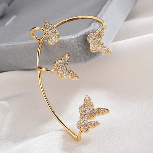 Sparkling zircon butterfly ear cuffs in gold-toned metal, featuring a delicate and elegant design for stylish accessorizing