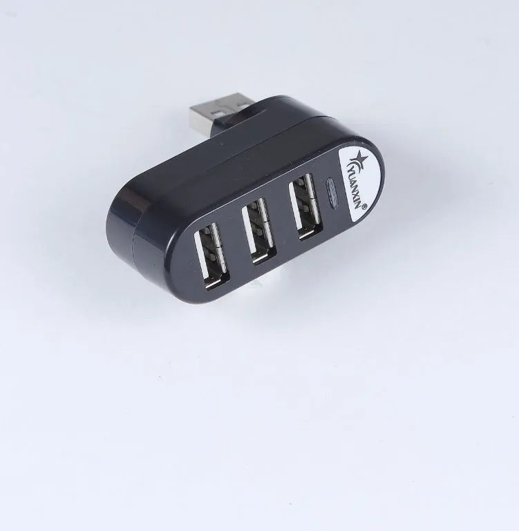 Black and white USB hub with a spinning multi-interface design on a desk.