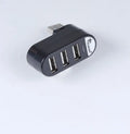 Black and white USB hub with a spinning multi-interface design on a desk.