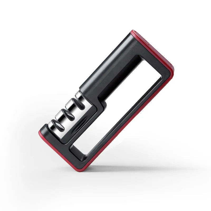 Black and red three-stage manual knife sharpener with rubber feet on base