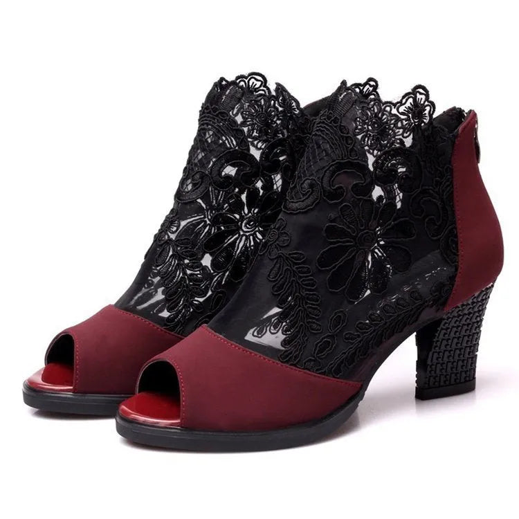 Black lace gladiator sandals with a square high heel, zip closure, and peep toe on a woman's foot