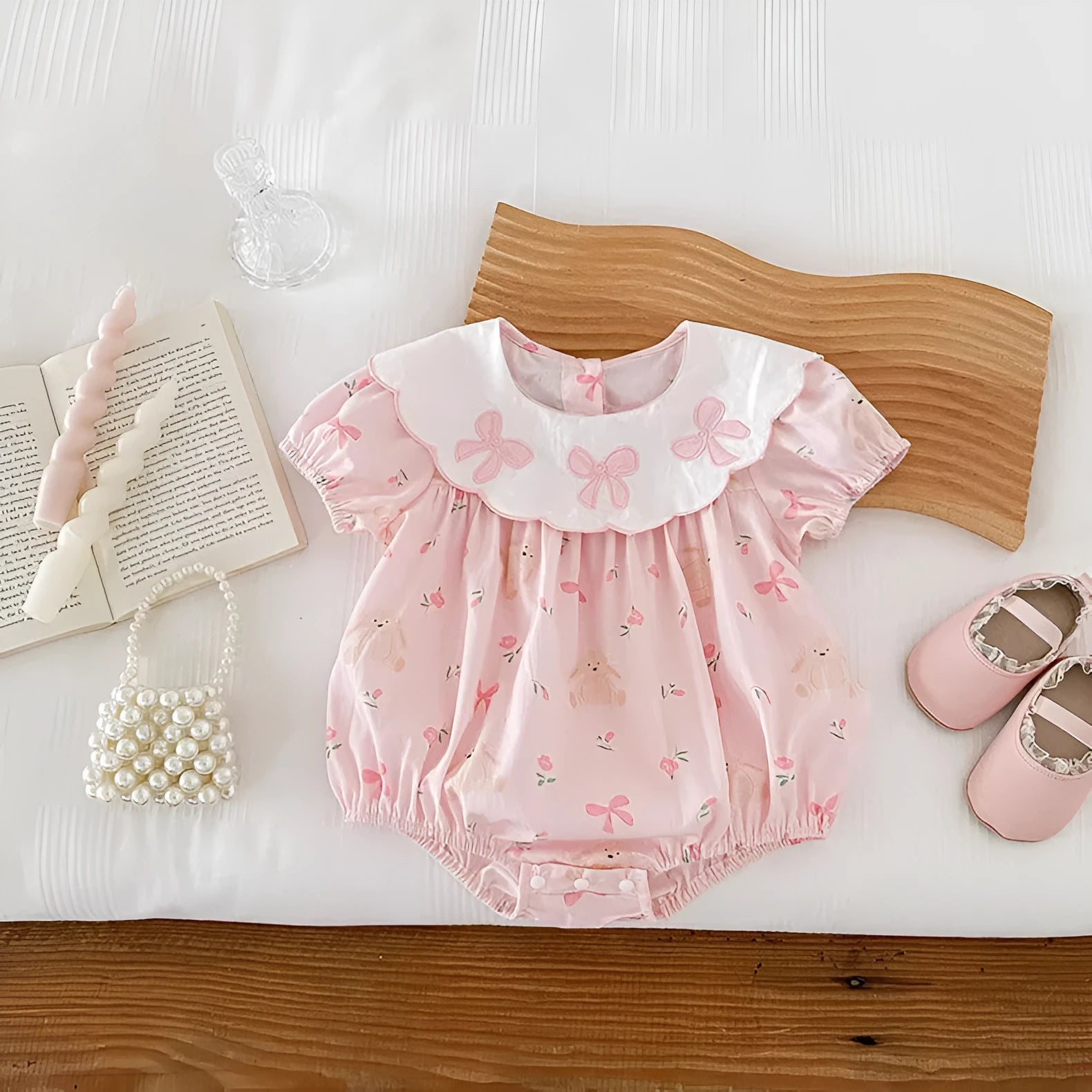 Pink cotton newborn triangle rompers with short sleeves and three bow details for summer outwear