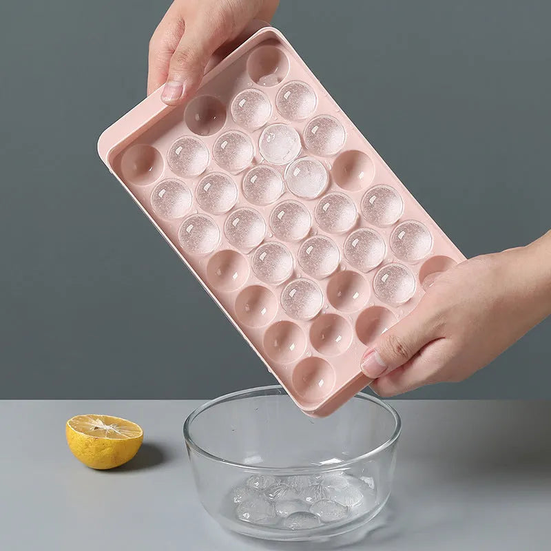 Sky blue and pink plastic round ice ball mould trays with 18 and 33 grids.