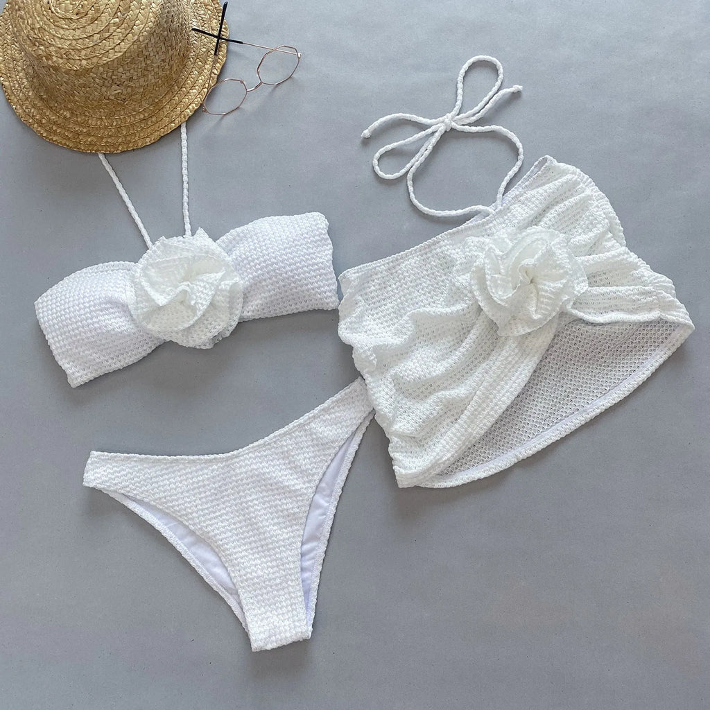 Women's white and purple three-piece bikini with 3D flower split design, includes bra, skirt, and briefs.