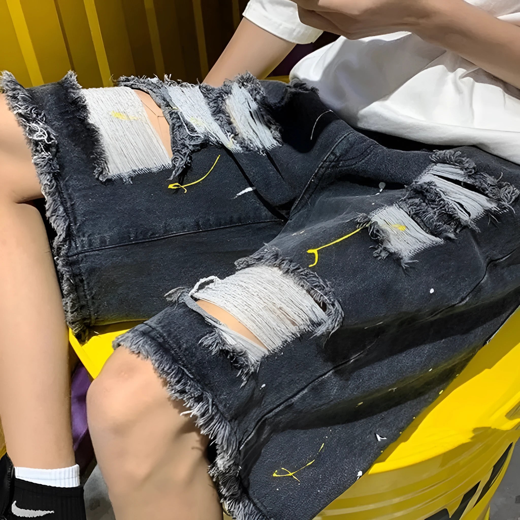 Man wearing loose-fit light blue water-washed denim shorts with hole details, for summer casual street style.