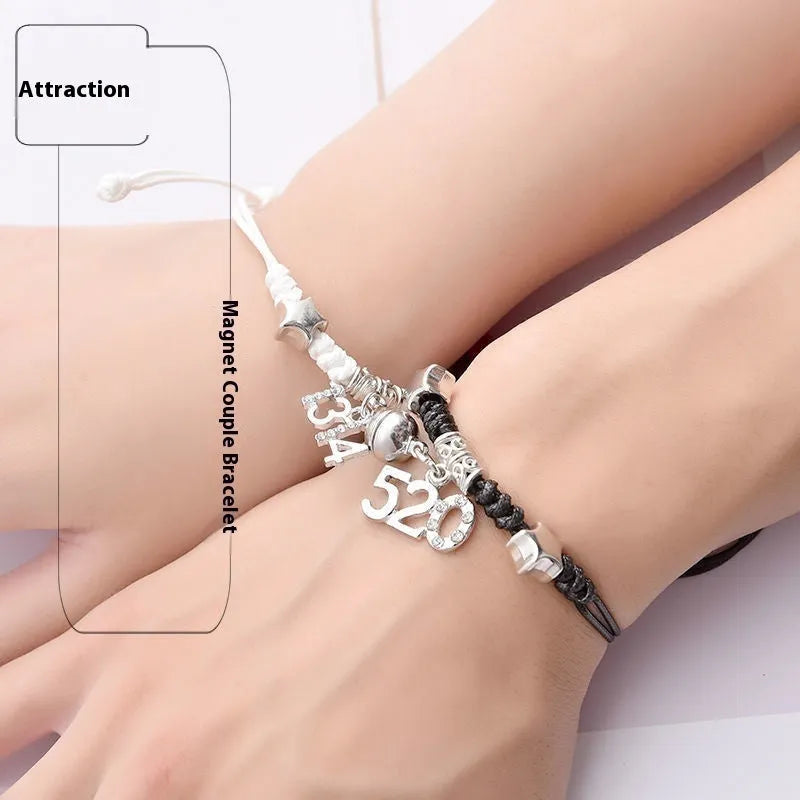 Pair of magnetic alloy bracelets with crown and heart charm designs on a wrist.